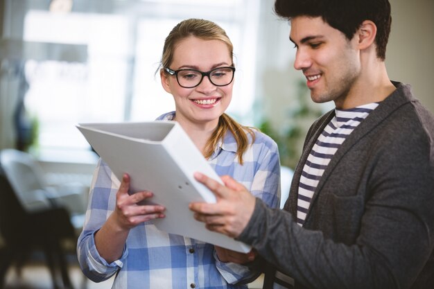 Compañeros de trabajo felices mirando el documento en la oficina creativa