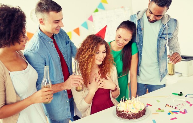 Foto compañeros de trabajo felices con pastel en la fiesta de cumpleaños de la oficina