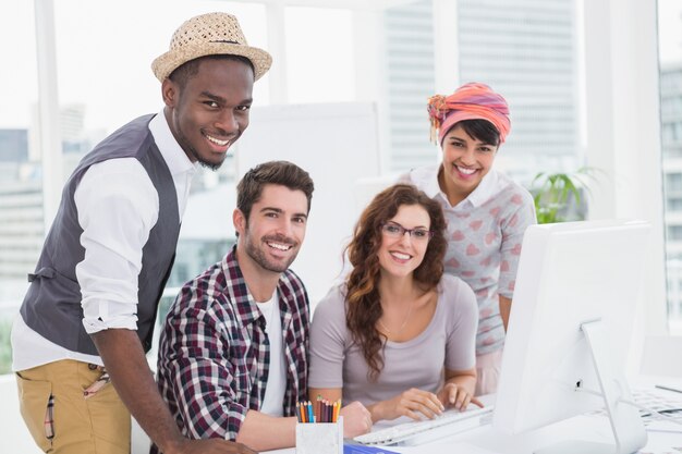 Compañeros de trabajo felices posando y mirando a la cámara