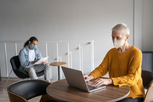 Foto compañeros de trabajo con máscaras médicas trabajando