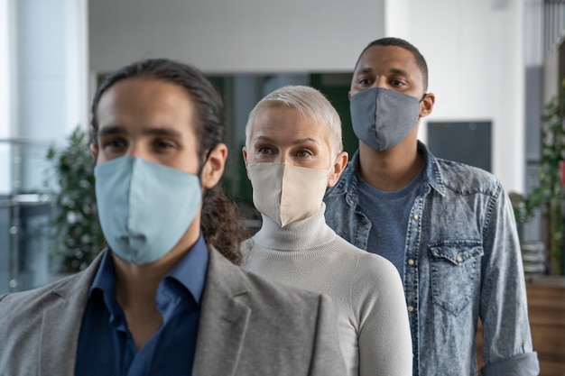 Compañeros de trabajo con máscaras médicas trabajando