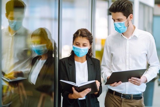 Compañeros de trabajo con mascarilla médica