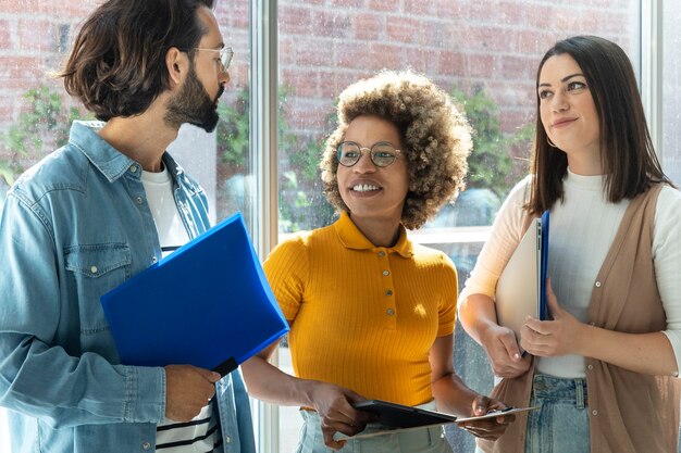 Foto compañeros de trabajo multirraciales se preparan para una reunión jóvenes empresarios adultos hablan en la oficina inicio