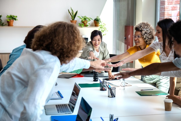 Compañeros de trabajo multirraciales se unen para celebrar el éxito del trabajo en equipo Celebración del trabajo en equipo empresarial