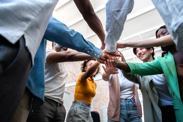 Compañeros de trabajo multirraciales unen sus manos en círculo. Concepto de colaboración de socios comerciales.