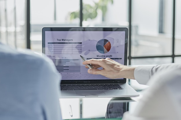 Foto compañeros de trabajo de la sociedad comercial que usan una tableta para trazar el informe y el profi de los estados financieros de la compañía