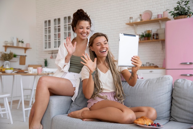 Foto companheiros de quarto sorridentes de tiro completo com tablet