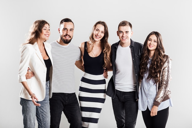 Compañía de amigos en ropa casual de moda están juntos y sonríen sobre un fondo blanco en el estudio.