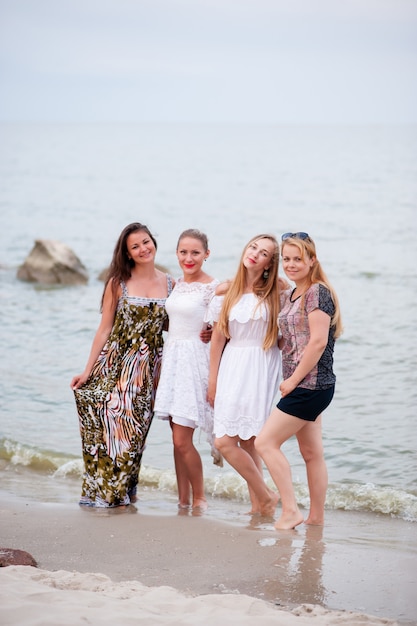 compañía de chicas jóvenes caminando por el mar