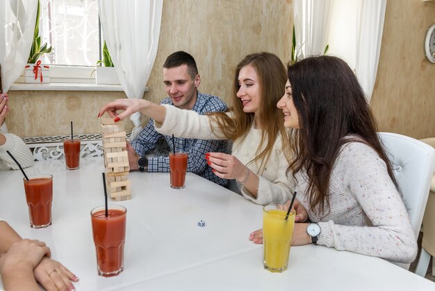 Foto la compañía de jóvenes juega al juego de mesa llamado jenga.