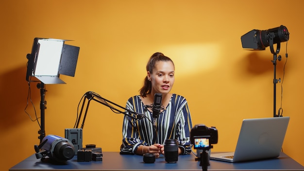 Foto comparación de lentes de cámara de un vlogger en línea en su estudio profesional. creador de contenido, influenciador estrella de los nuevos medios en las redes sociales, hablando, equipo de fotos de video para un programa web en línea