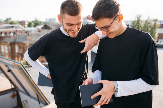 Compartiendo información. Comunicación de amigos universitarios. Hombre mostrando su cuaderno con algunas notas. Estudiar el concepto de conocimiento de la educación