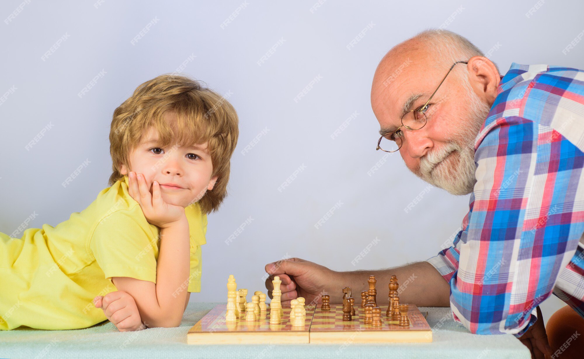 Competição de xadrez infantil e de tabuleiro, garotinho jogando xadrez com  o vovô.