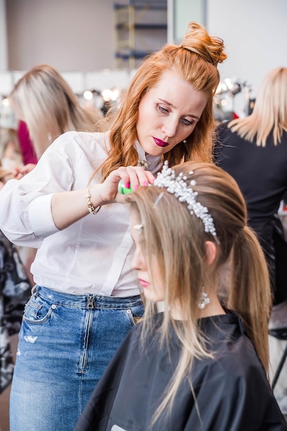 Competição entre cabeleireiros de noivas O cabeleireiro faz um penteado de casamento