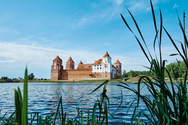 Complejo del castillo de mir en un día de verano con azul cielo nublado hito turístico en el monumento cultural de bielorrusia antigua fortaleza