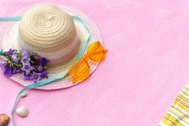 Complementos para las vacaciones de verano con sombrero de paja y manta con gafas de sol.