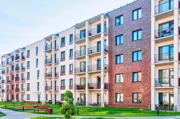 Complexo de novos prédios de apartamentos com plantas de flores e instalações ao ar livre.