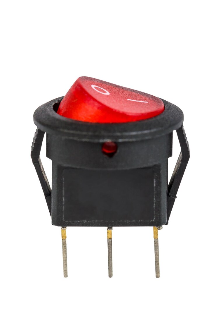 Foto componente electrónico del interruptor de alimentación eléctrica rojo aislado sobre fondo blanco.