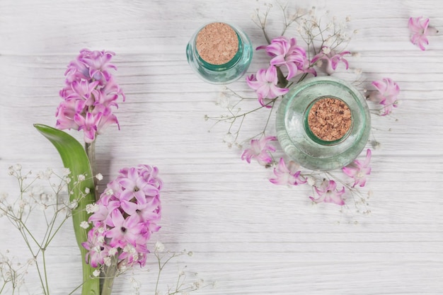 Composição abstrata de flores de jacintos roxos e frascos de cosméticos orgânicos com óleo essencial