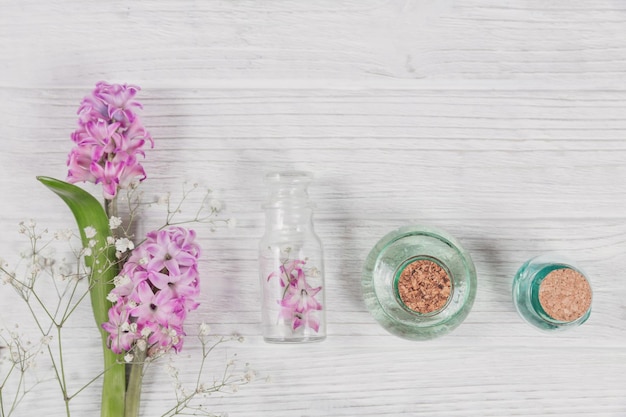 Composição abstrata de flores frescas de jacintos roxos e frascos de cosméticos orgânicos com óleo essencial