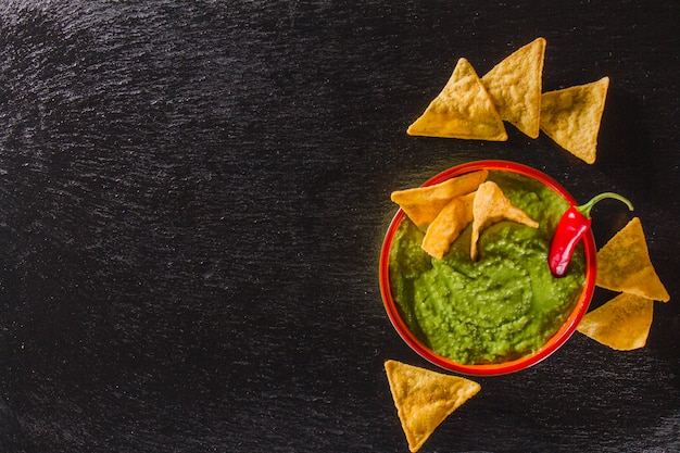 Composição artística com guacamole e nachos