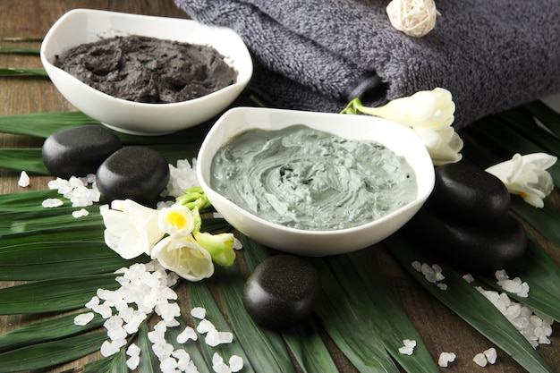 Foto composição com argila cosmética para tratamentos de spa em fundo de folhas de palmeira