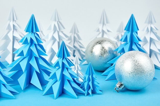 Composição com árvores de Natal de papel azul e branco e enfeites de bola