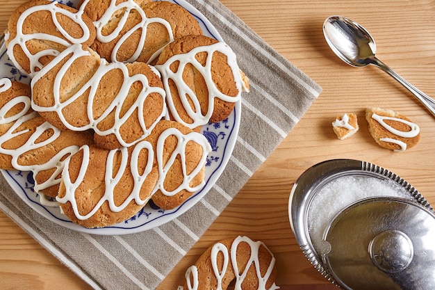 Composição com biscoitos sobre uma mesa de madeira com açúcar e colher de chá