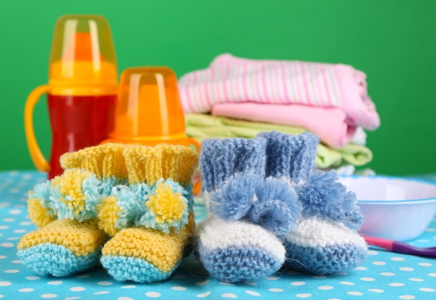 Composição com botas de crochê para roupas de bebê e outras coisas na cor de fundo