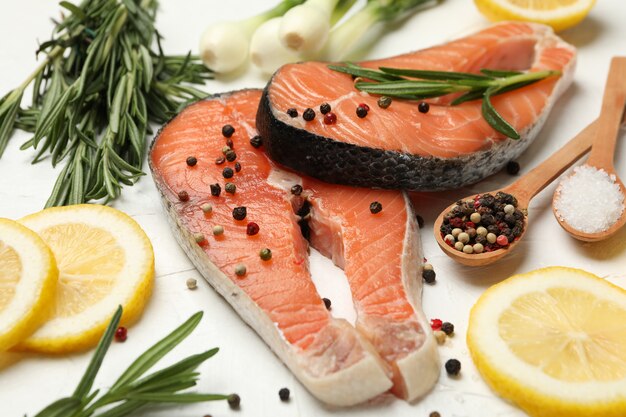 Composição com carne de salmão e especiarias em branco isolado, close-up