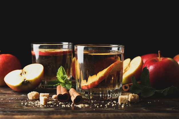 Composição com cidra, açúcar, canela e maçãs na mesa de madeira