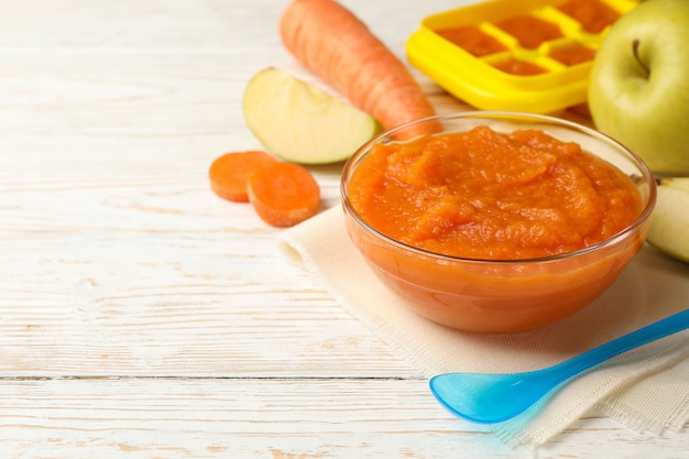 Composição com comida para bebê no fundo branco de madeira