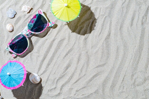 Composição com conchas e óculos de sol na areia do mar Conceito de viagens e férias