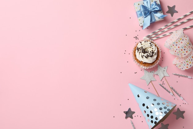 Composição com cupcake e aniversário acessórios em fundo rosa, espaço para texto