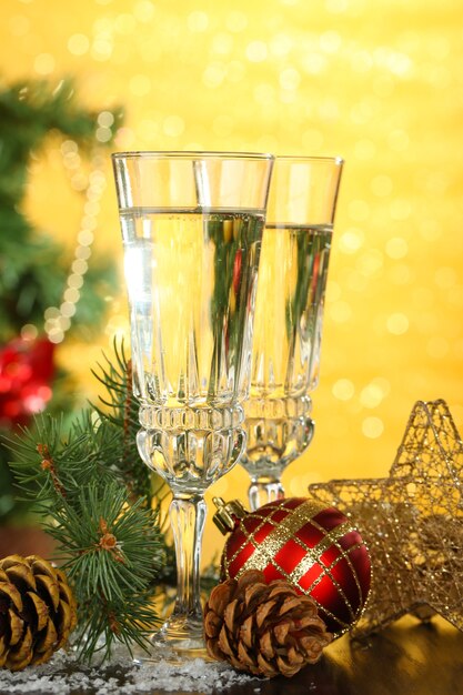 Foto composição com decorações de natal e duas taças de champanhe, em fundo brilhante