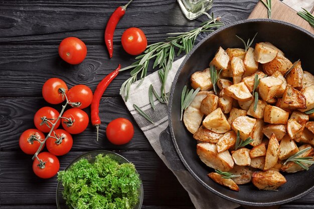 Composição com deliciosas batatas de alecrim na panela na mesa