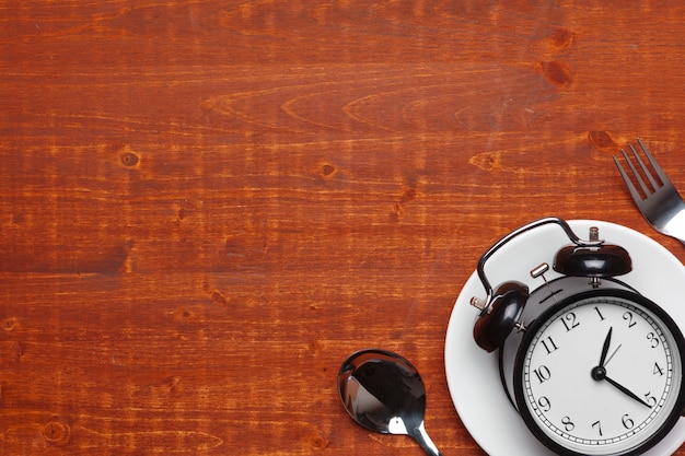 Composição com despertador, prato e utensílios