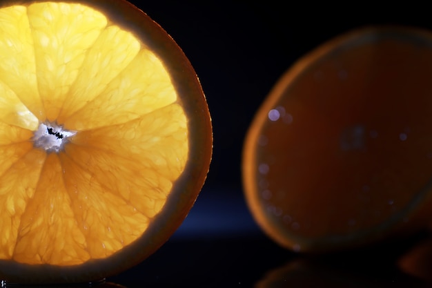 Composição com fatias de laranja e toranja sobre um fundo preto
