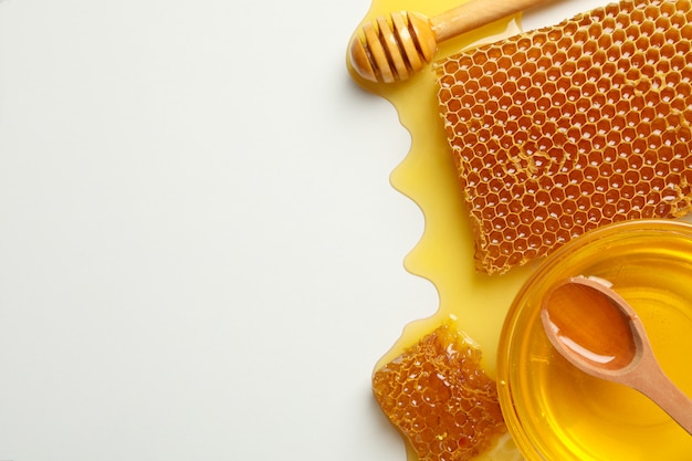 Composição com favos de mel, mel e concha em fundo branco