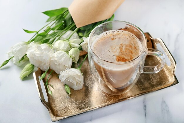 Composição com lindas flores e xícara de café na mesa