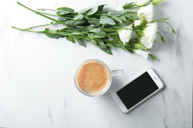 Composição com lindas flores e xícara de café na mesa