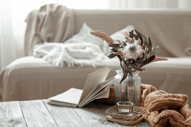 Composição com livro, flor seca e elemento tricotado no interior da sala