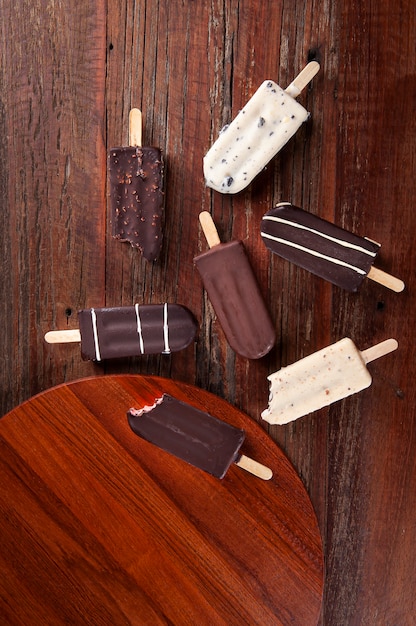 Composição com picolés de chocolate em fundo de madeira. Vista do topo