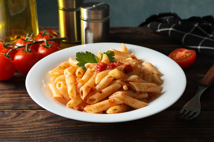 Foto composição com prato de massa saborosa na parede de madeira. cozinhar macarrão