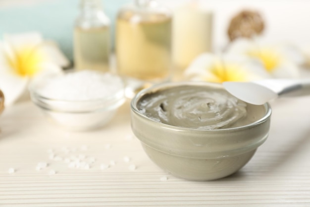 Composição com produto cosmético para envoltórios corporais de spa em fundo branco de madeira