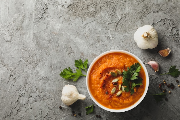 Composição com tigela de sopa de abóbora