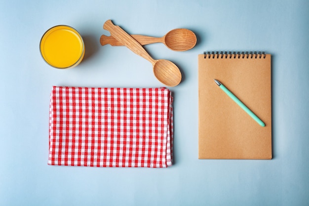 Composição com toalha e utensílios de cozinha na superfície colorida