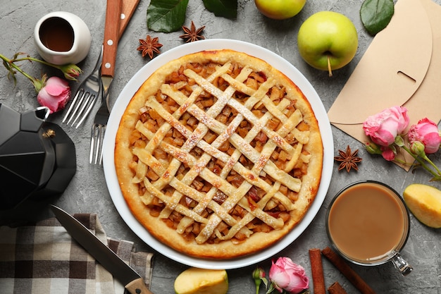 Composição com torta de maçã e ingredientes em fundo cinza, vista superior