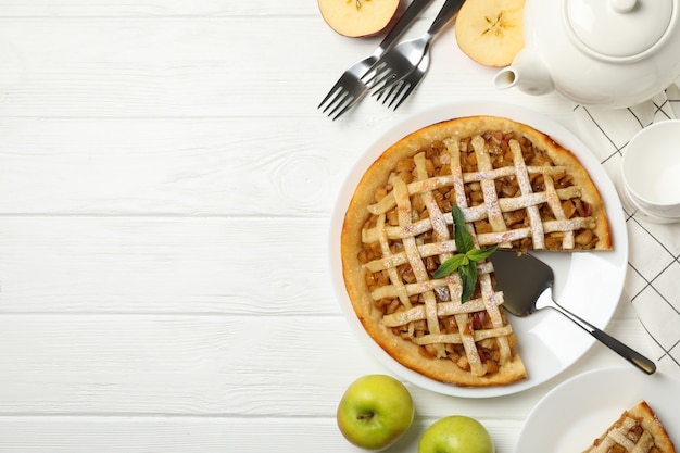Composição com torta de maçã no fundo branco de madeira. almoço saboroso. café da manhã caseiro