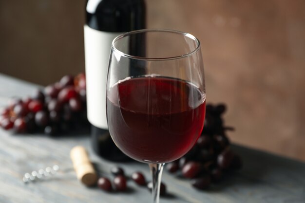 Composição com vinho, cortiça e uva na mesa de madeira